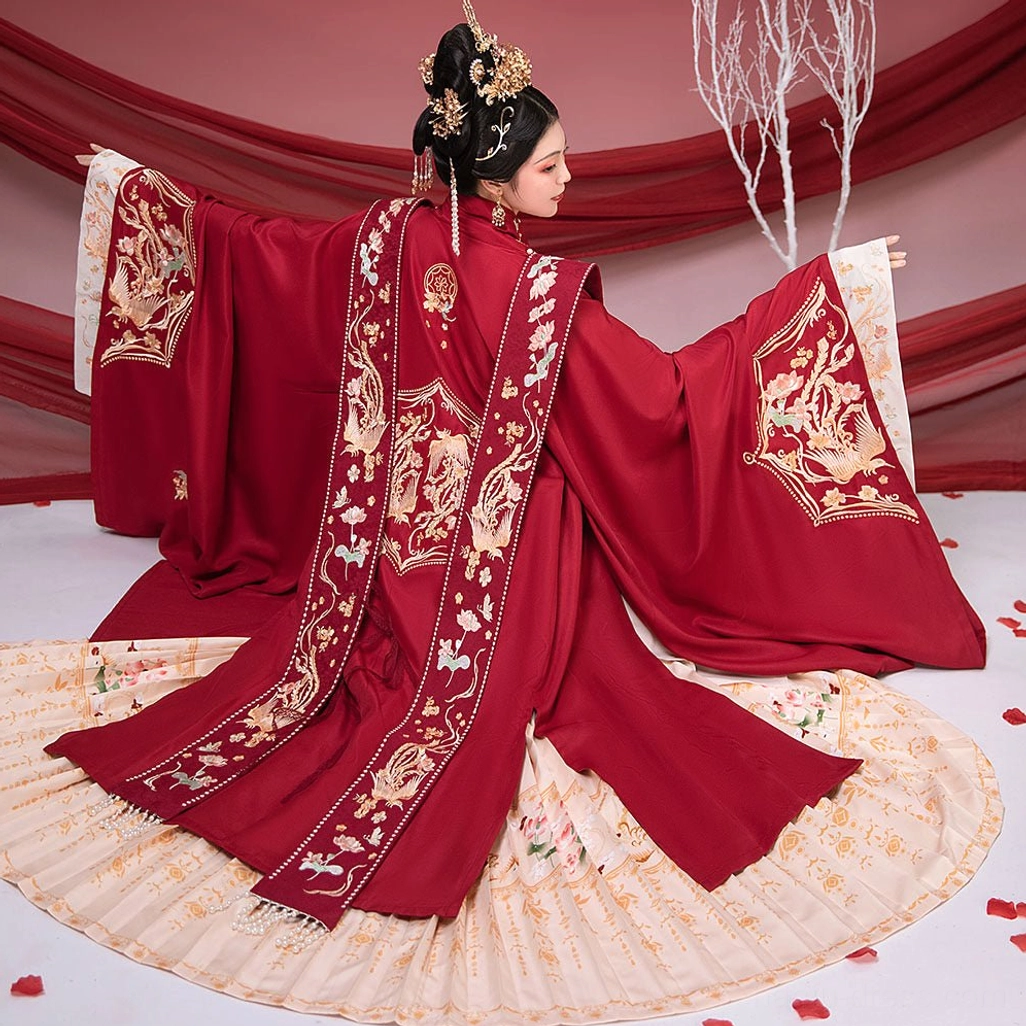 Back view of a crimson Ming Dynasty bridal Hanfu with wide sleeves, full gold phoenix and floral embroidery, embroidered xiapei sash, and cream pleated mamian skirt