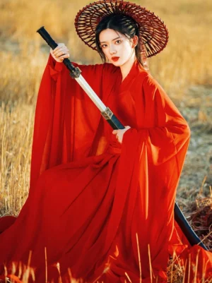 Crimson red Wei Jin style ruqun Hanfu with cross-collar top, fitted waist, lightweight flowing fabric, and wide sleeves in an outdoor wheat field