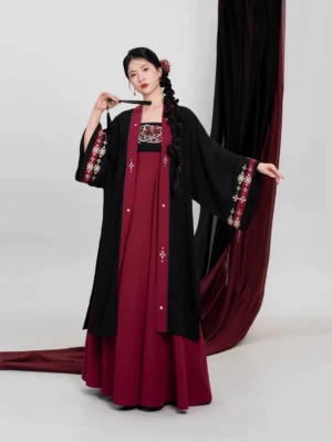 Front view of a crimson scarlet modern Tang Dynasty Hanfu set with a long black Beizi jacket, embroidered burgundy slip dress, traditional braided hairstyle, and Chinese hairpin