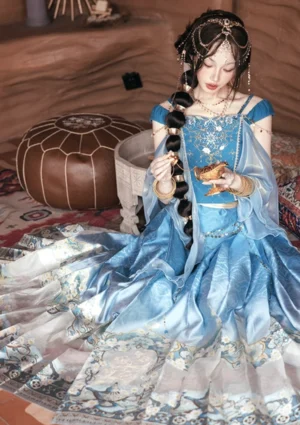 Dancing Jasmine blue modern Hanfu mamianqun outfit shown in a full body seated pose with flowing sheer shawl and gold embroidered horse face skirt