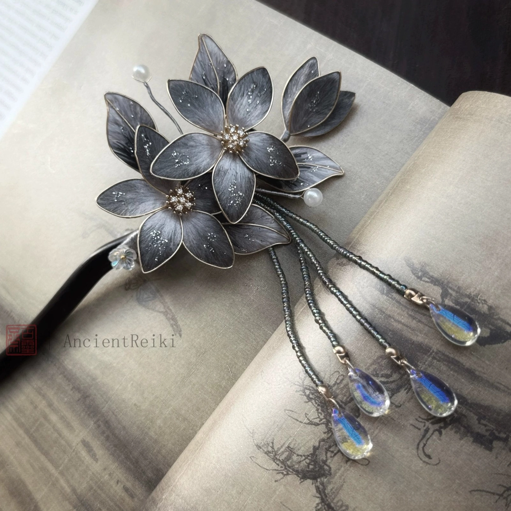 Right angle view of Danqing Chinese floral hair stick for Hanfu, featuring layered dark petals, gold trim and long beaded tassels with multiple shimmering pendants