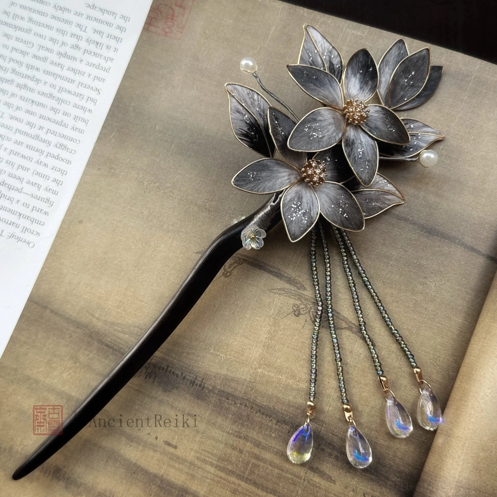 Danqing lotus tassel Chinese hair stick for Hanfu and qipao, showing gold-edged dark flowers, pearl details and uniform shimmering beaded tassels