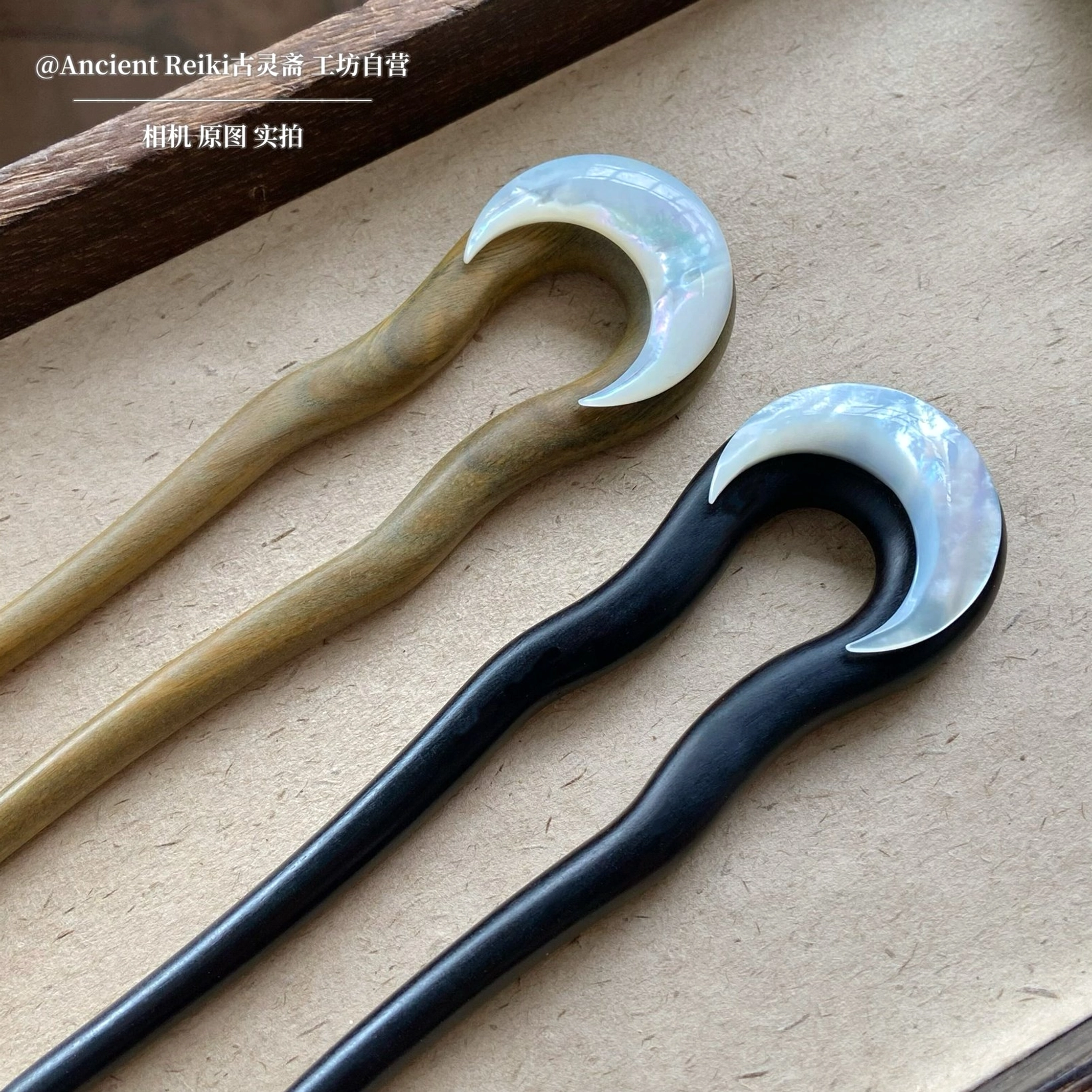 Pair of dark and light U-shaped Chinese hair sticks with polished wood finish and mother-of-pearl crescent moon ornaments