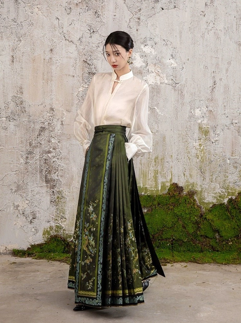 Modern Chinese Hanfu horse face skirt shown from the front right side with dark green pleats, floral patterns, ornate woven borders, and traditional styling