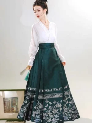 Dark green pleated mamianqun horse face skirt paired with a white V-cross-collar Hanfu blouse and folding fan in a side three-quarter view