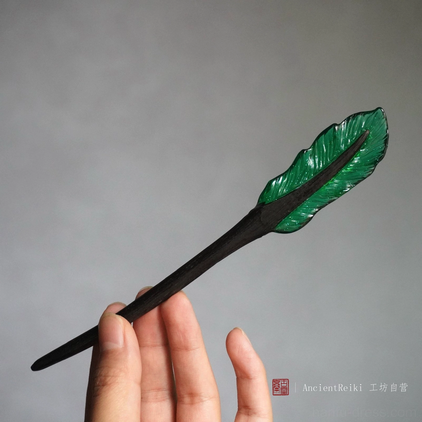 Dark green translucent feather Chinese hair stick with textured feather veins and smooth black wooden shaft