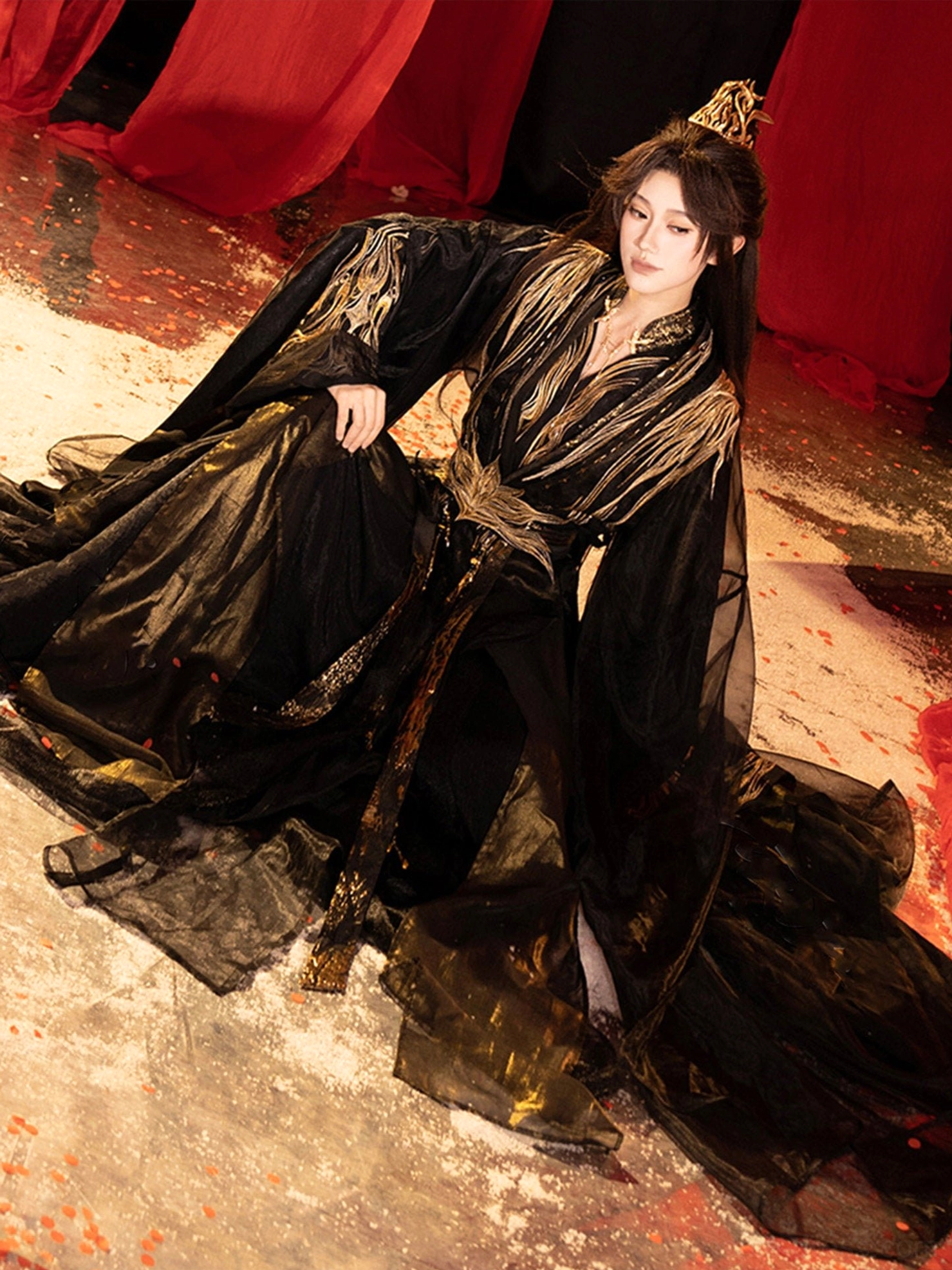 Low-angle view of a dark Qiyao Ruqun Hanfu with embroidered sleeve cuffs, long gold waist sash, tassel details and spread-out flowing train