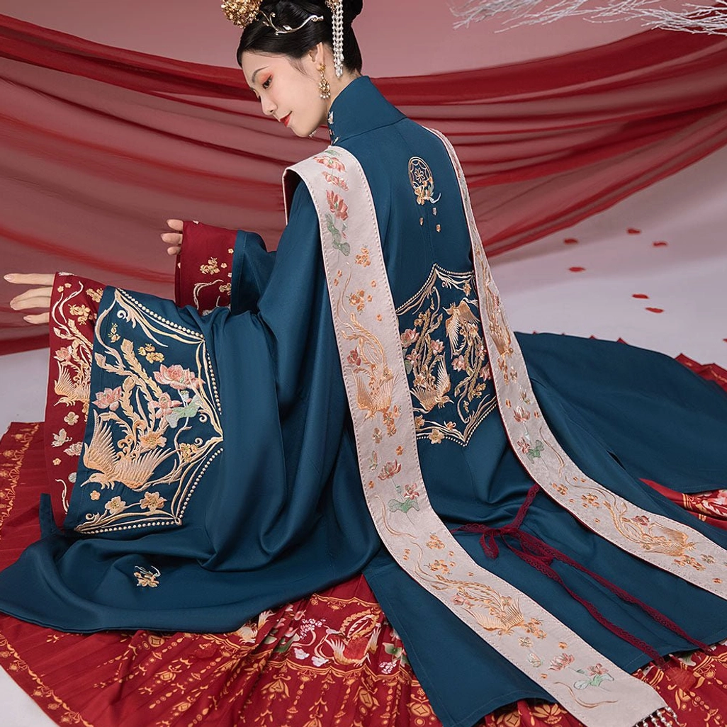 Side and back view of a dark teal Ming Dynasty bridal Hanfu outer robe with gold phoenix embroidery, embroidered cuffs, stand collar, and flowing off-white xiapei sashes