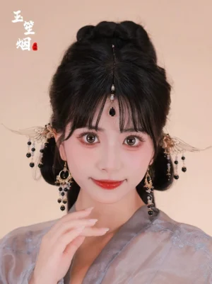 Complete Dark Wings Hanfu hair accessories set styled on a woman wearing grey traditional Chinese Hanfu with gold wing hairpins, black forehead pendant, and beaded tassel earrings