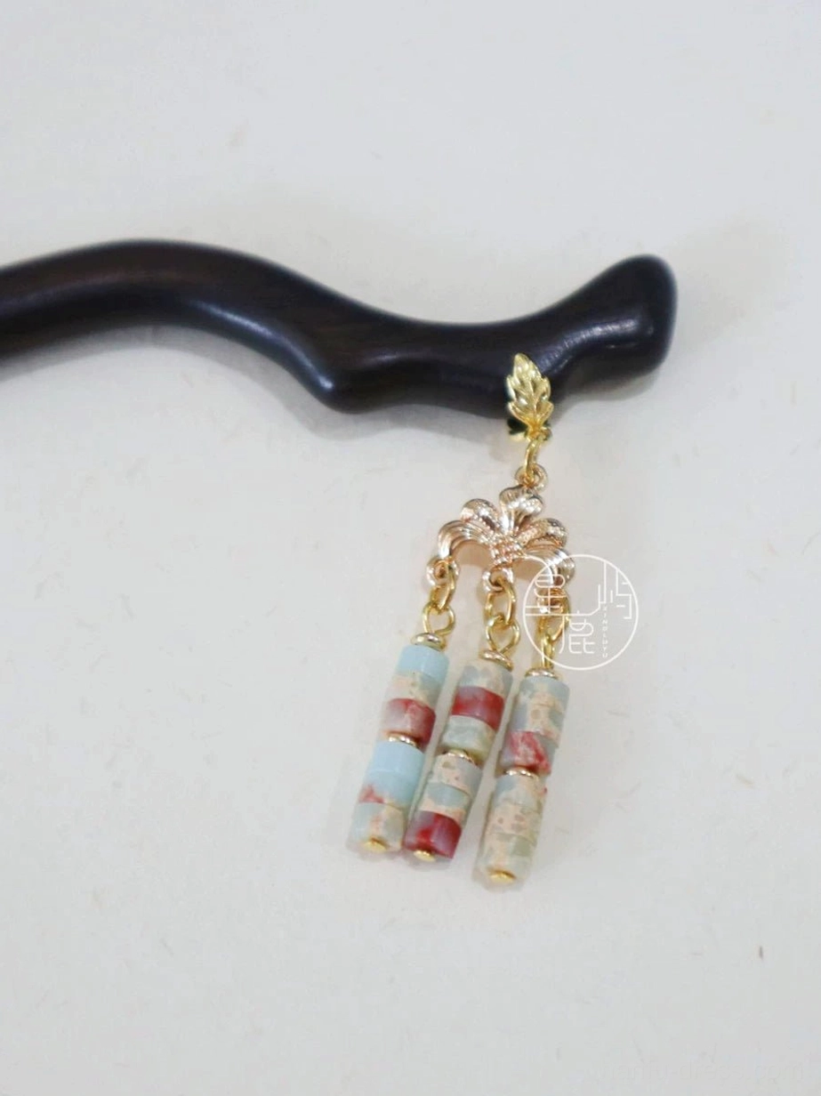 Close-up of a dark wooden Chinese hair stick with curved shaft and natural stone tassel pendant showing its detailed texture