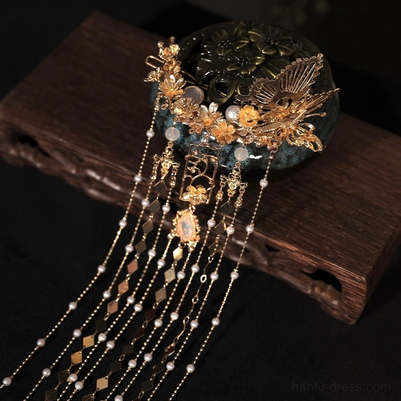 Close-up of ornate Chinese bridal tassel hairpin with gold floral metalwork pearl accents and crystal-style centerpiece