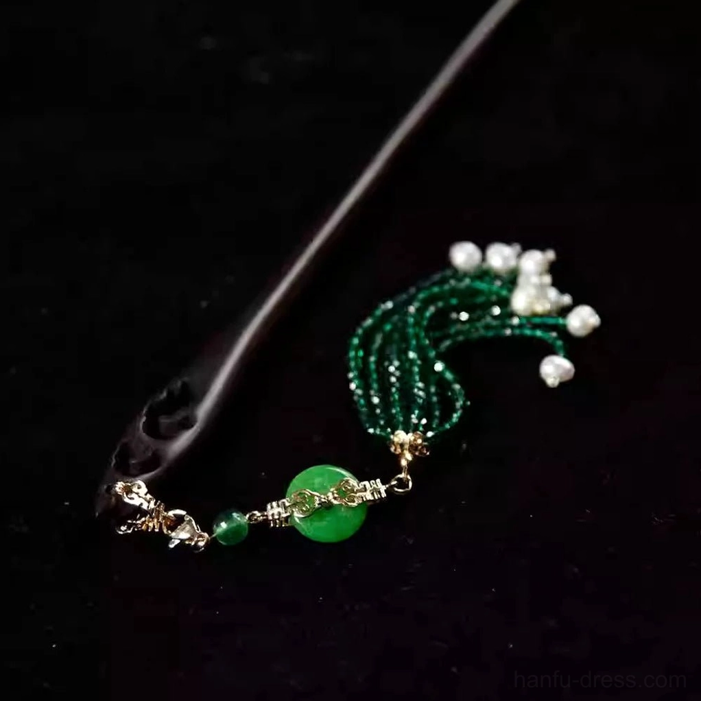 Decorative Chinese hair stick and tassel accessory with curved green beaded pendant, round jade-style charm, pearl-like clusters, and gold links