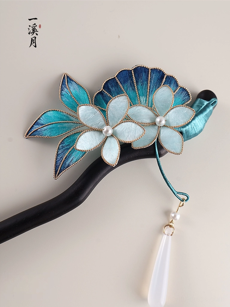Front flat lay view of deep sea blue floral traditional Chinese hair stick with two pearl-centered flower clusters and tassel