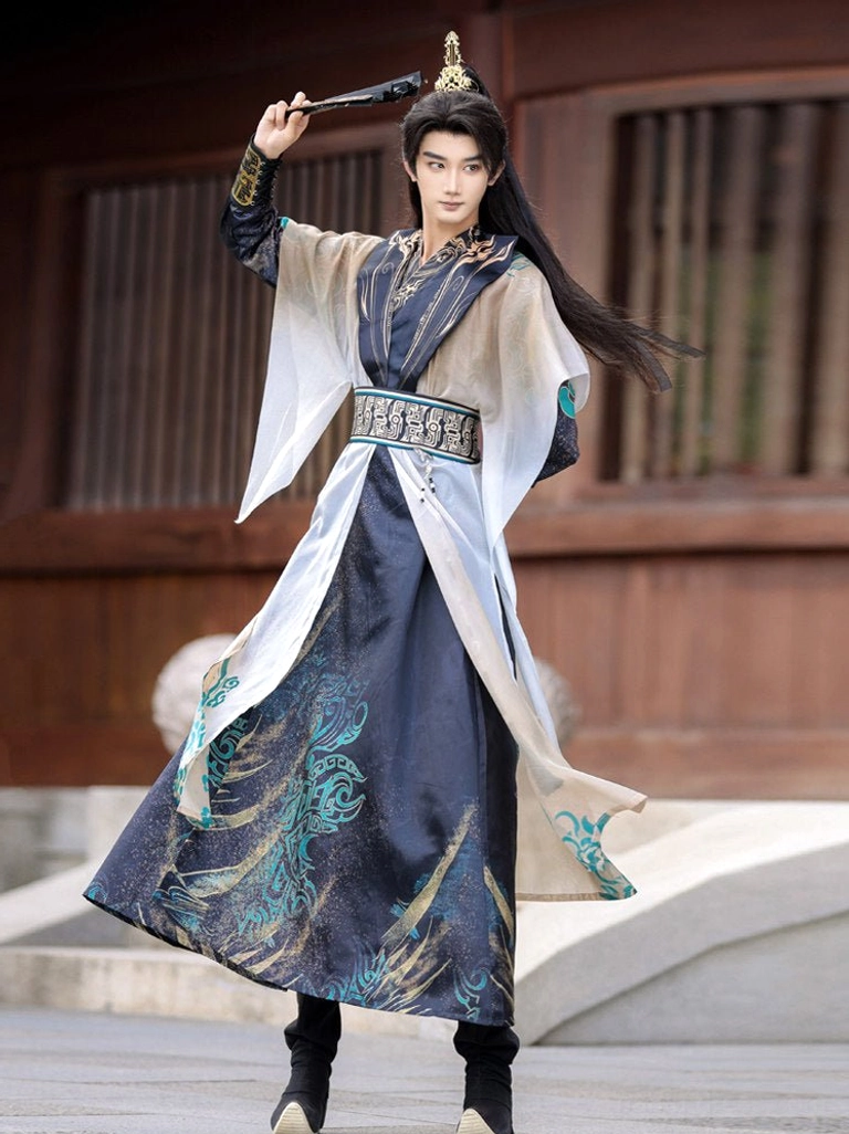 Three quarter view of male wuxia hanfu set with flowing sheer cape layer, turquoise and gold inspired robe patterns and folding fan