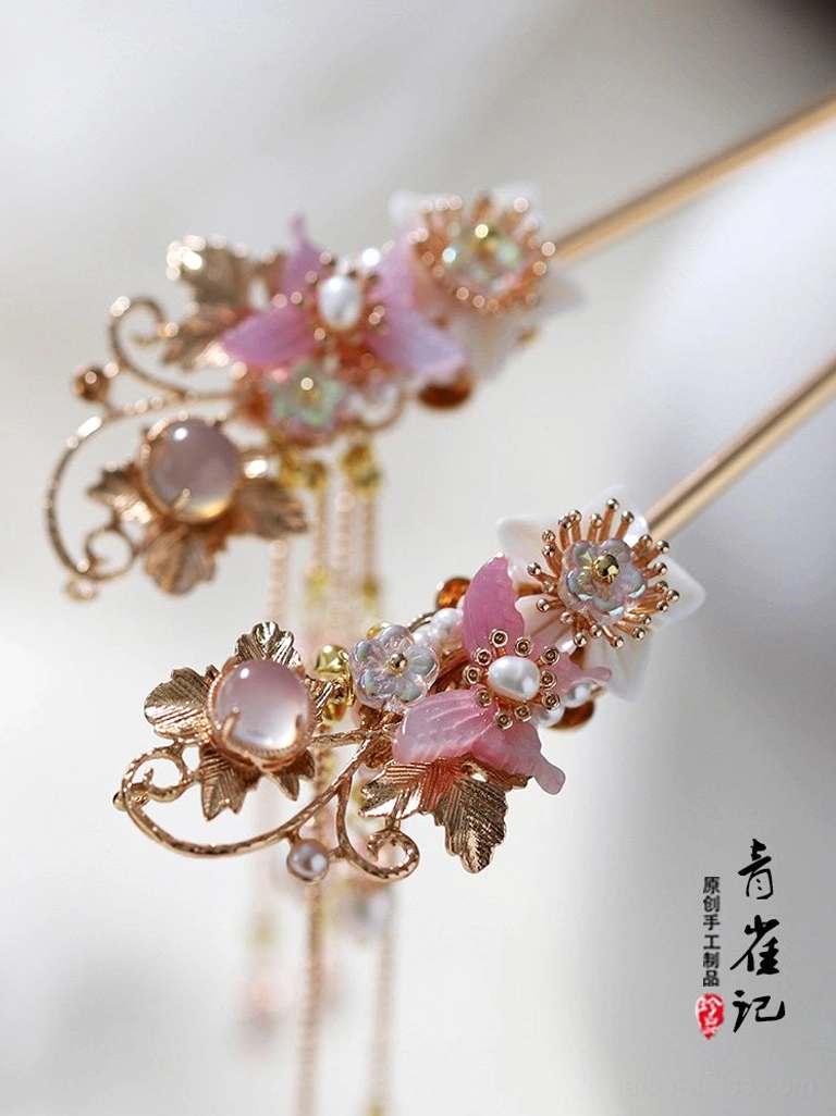 Close-up of detailed Chinese hair sticks with gold metal inlays pink flower clusters and long pearl tassels