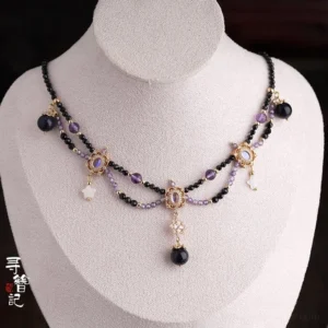 Double-layer Hanfu Chinese necklace displayed on a jewelry mannequin with black and purple bead chains, gold filigree connectors, dark central pendant, and teardrop charms