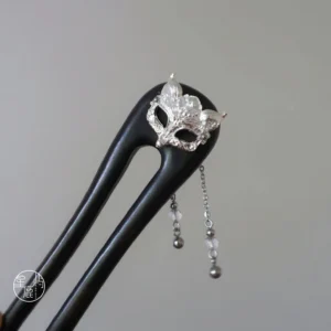 Close-up side view of double-pronged fox Chinese hair stick with dark wooden prongs, silver fox mask ornament and beaded tassel for Hanfu hairstyles