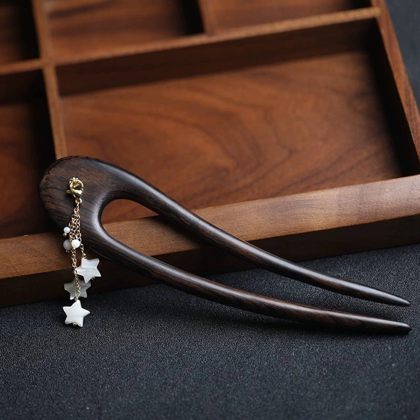 Side view of the dark wood U-shaped double-pronged Moon Rabbit hair stick showing the golden tassel connector