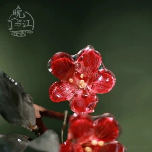 Top view of a double crabapple flower Chinese hair stick showing two bright red resin blossoms, yellow stamens, and matching grey-green decorative leaves