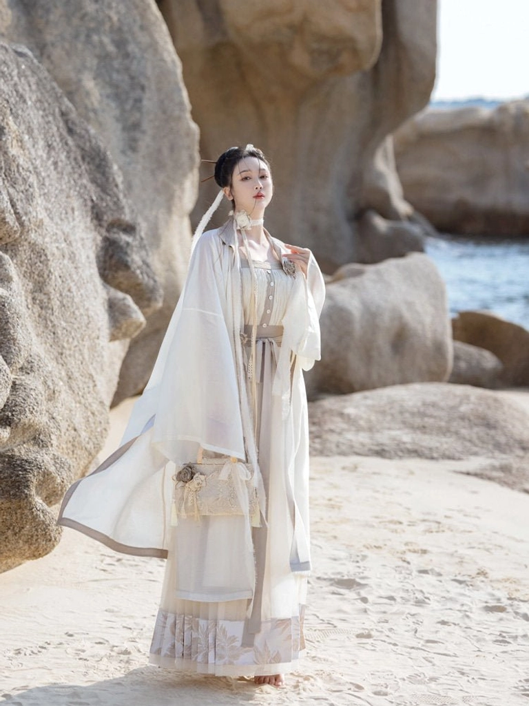 Dream of Mountains Hanfu dress set shown in a full front view on a sandy coastal beach, featuring a floor length mamian skirt, sheer wide sleeve robe, and structured underbust camisole