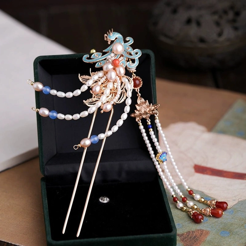 Close angled view of a blue cloisonne phoenix Hanfu hairpin with pearl tassels red agate accents and double hair sticks