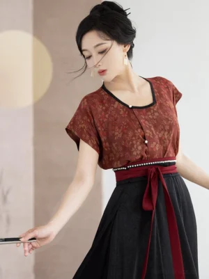 Close-up of rust red floral Hanfu beizi top with black neckline trim decorative buttons and pearl waist detail