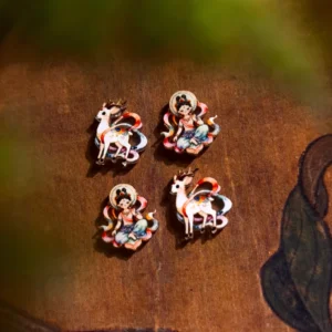 Dunhuang Apsara and Nine-Colored Deer stud earrings with hand-painted Chinese art details displayed on a vintage wooden background with leaf motifs