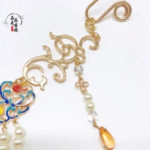 Close-up side view of Dunhuang style Chinese pearl necklace showing gold scroll clasp, crystal detail, enamel ornament, and amber teardrop pendant