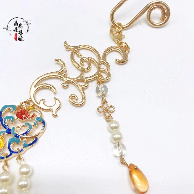 Close-up side view of Dunhuang style Chinese pearl necklace showing gold scroll clasp, crystal detail, enamel ornament, and amber teardrop pendant