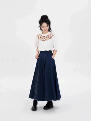 Female model wearing a Dunhuang embroidery cotton T-shirt and dark blue modern Hanfu skirt with practical skirt pockets