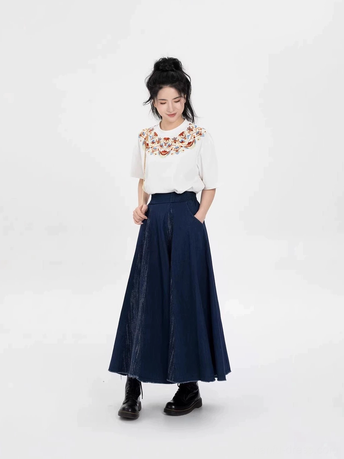 Female model wearing a Dunhuang embroidery cotton T-shirt and dark blue modern Hanfu skirt with practical skirt pockets