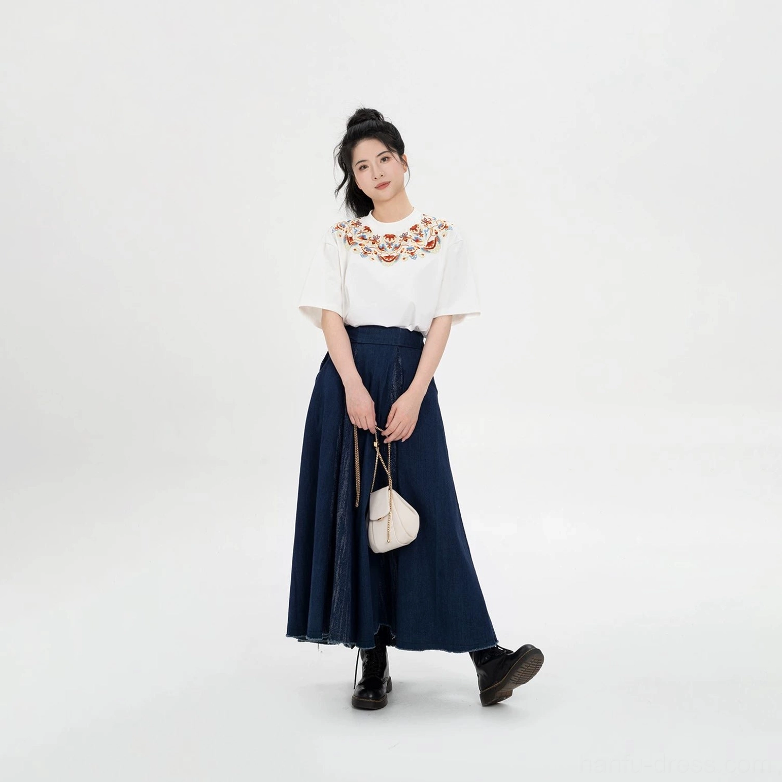Side view of a Dunhuang embroidery T-shirt and navy skirt matching set with frayed hem styled with black boots