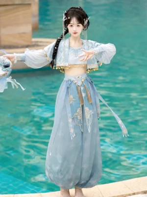 Front view of a complete Dunhuang Feitian dance costume set with turquoise blue fabric, gold coin edging, sheer sleeves, and floral dance prop