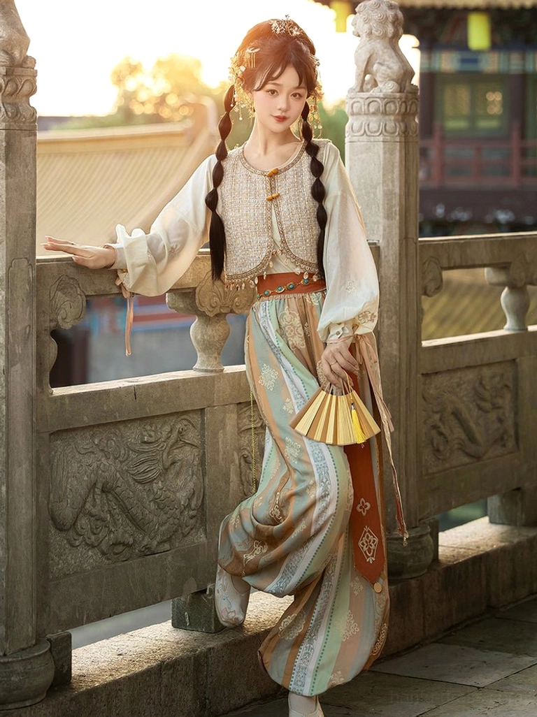 Dunhuang inspired Feitian Hanfu outfit in warm earth tones with cream sleeves textured vest patterned bloomers and golden folding fan