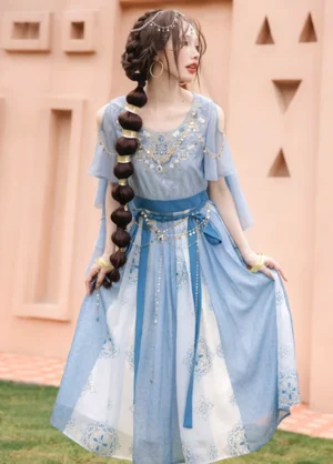 Model wearing a Dunhuang Feitian modern Hanfu dance dress with mist blue cape sleeves, teal sash, floral print skirt, and beaded waist chain outdoors