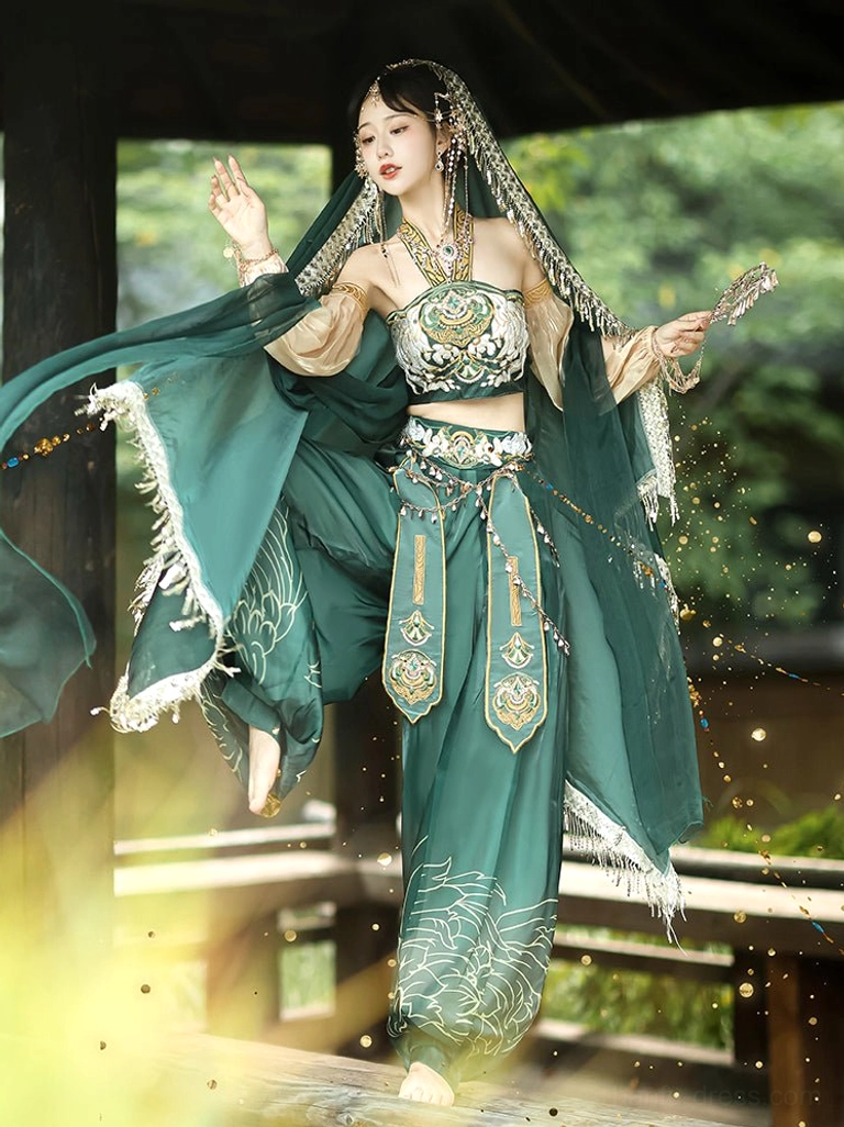 Dynamic low-angle view of a Dunhuang Feitian Tang Dynasty dance costume with flowing sheer green veil, embroidered waist belt, split-leg performance pose, and dance prop