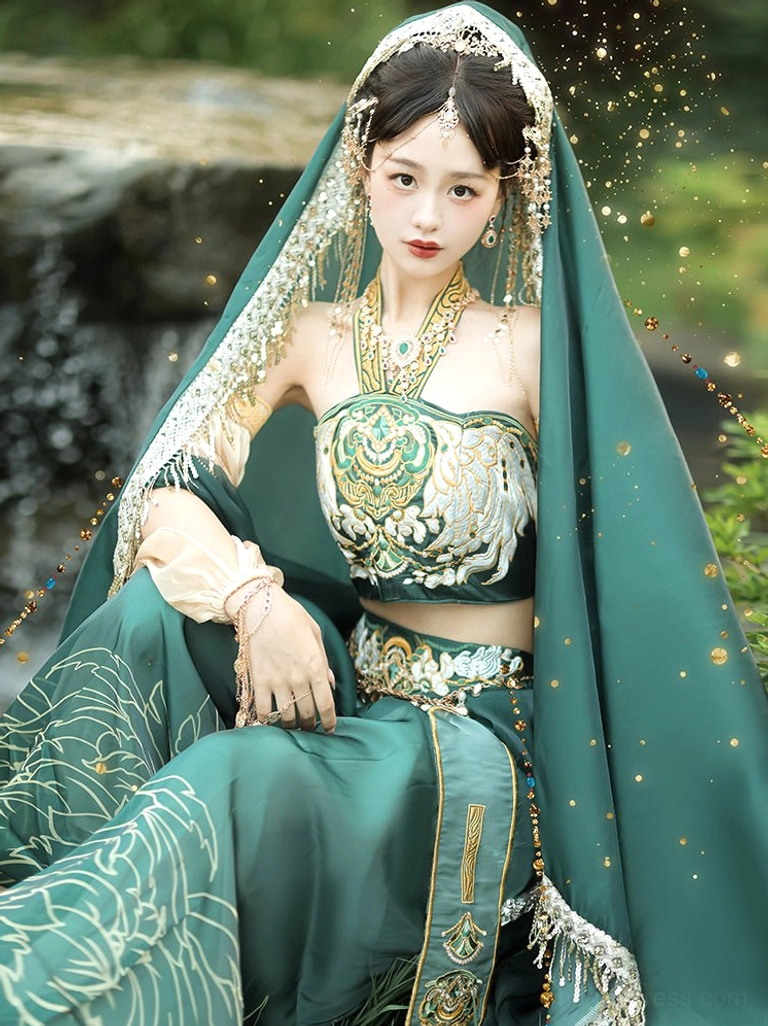 Front sitting close-up of a Dunhuang Feitian Tang Dynasty performance outfit with halter embroidered top, floral wide-leg bloomers, glittering green sheer veil, and retro gold jewelry