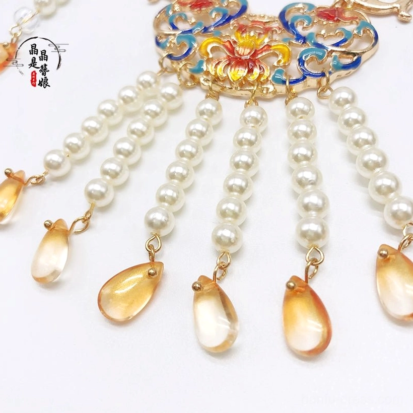 Top view close-up of floral enamel centerpiece on Dunhuang-inspired Chinese necklace with layered freshwater pearl tassels and teardrop charms