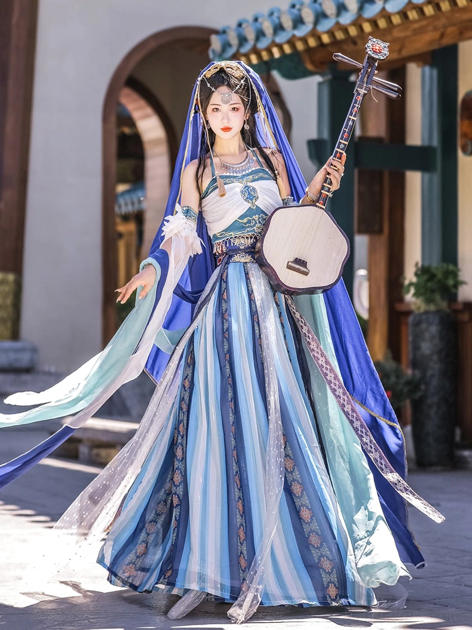 Low-angle front view of Dunhuang Goddess Feitian Tang Dynasty Hanfu with layered sheer veils, striped full-length skirt, blue headwear, and celestial dancer styling in an ancient courtyard