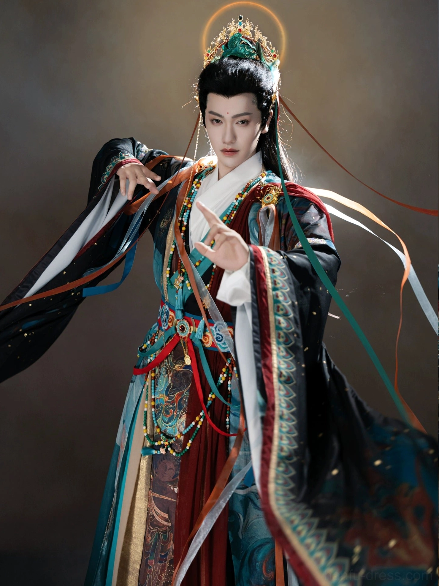 Male model wearing black Dunhuang inspired Xianxia Hanfu costume with wide sleeves, ornate colorful trim, and mythical spell-casting pose