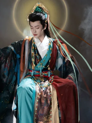 Dunhuang Godly Immortal Hanfu for men in a seated three-quarter view with layered Xianxia robe, flowing silk ribbons, and beaded waist accessories