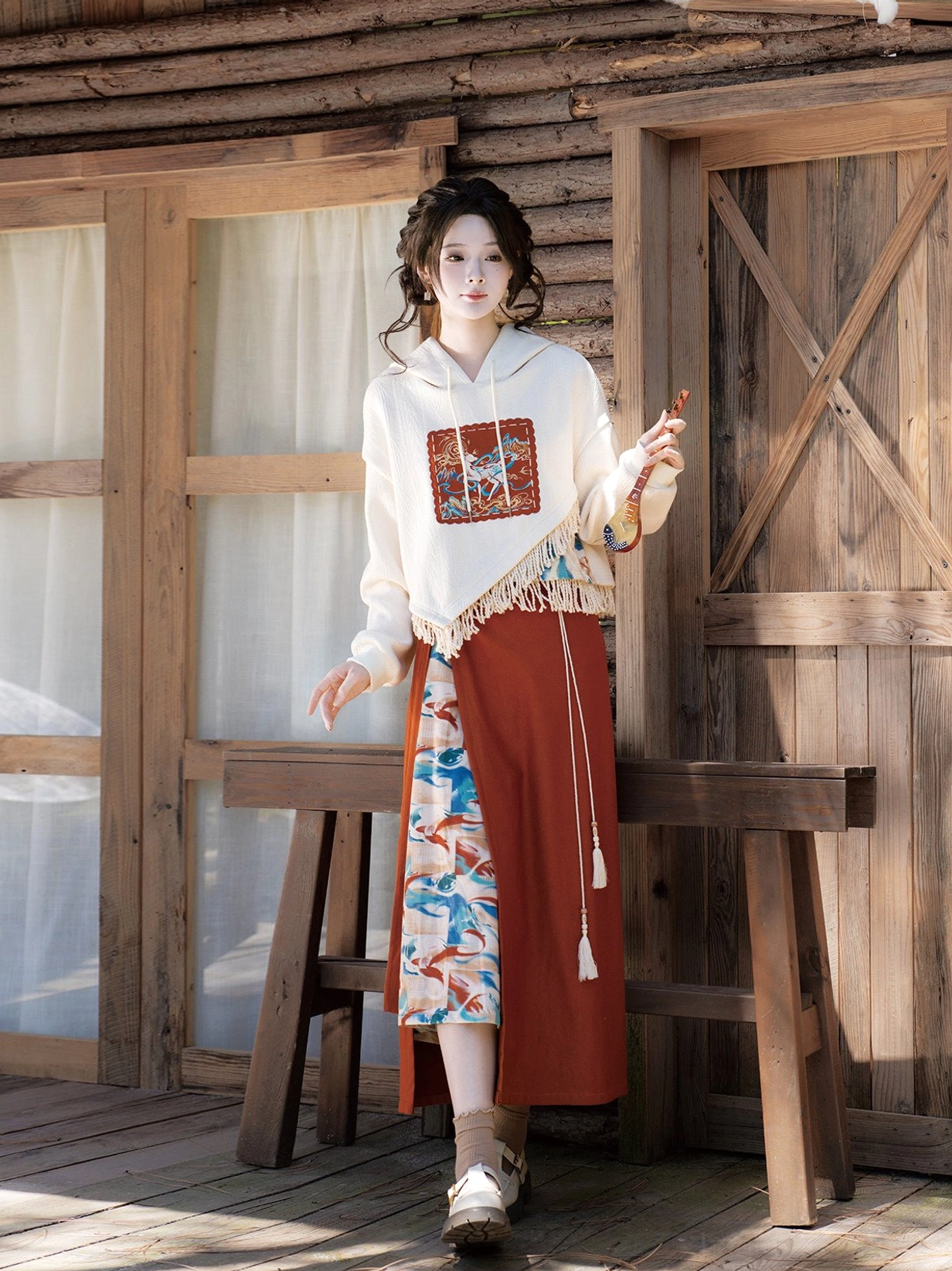 Dunhuang-inspired modern Hanfu clothing set with flying-Apsaras printed skirt panel and tassel-trimmed hooded sweater shown from the side