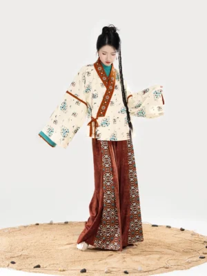Three-quarter view of a Dunhuang-inspired women’s Hanfu outfit with wide sleeves, printed cross-collar jacket, contrasting reddish-brown trim, and matching wide-leg pants