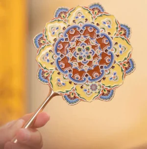 Close-up front view of a Dunhuang lotus caisson Chinese hand mirror with layered floral shape, colorful enamel-style Mogao Cave patterns, turquoise blue yellow and terracotta details, and a polished gold-tone handle