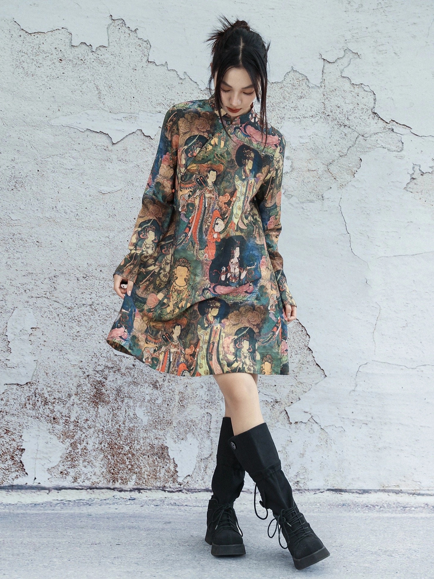 Full body side-front view of loose A-line Dunhuang mural print long sleeve cheongsam dress styled with black combat boots