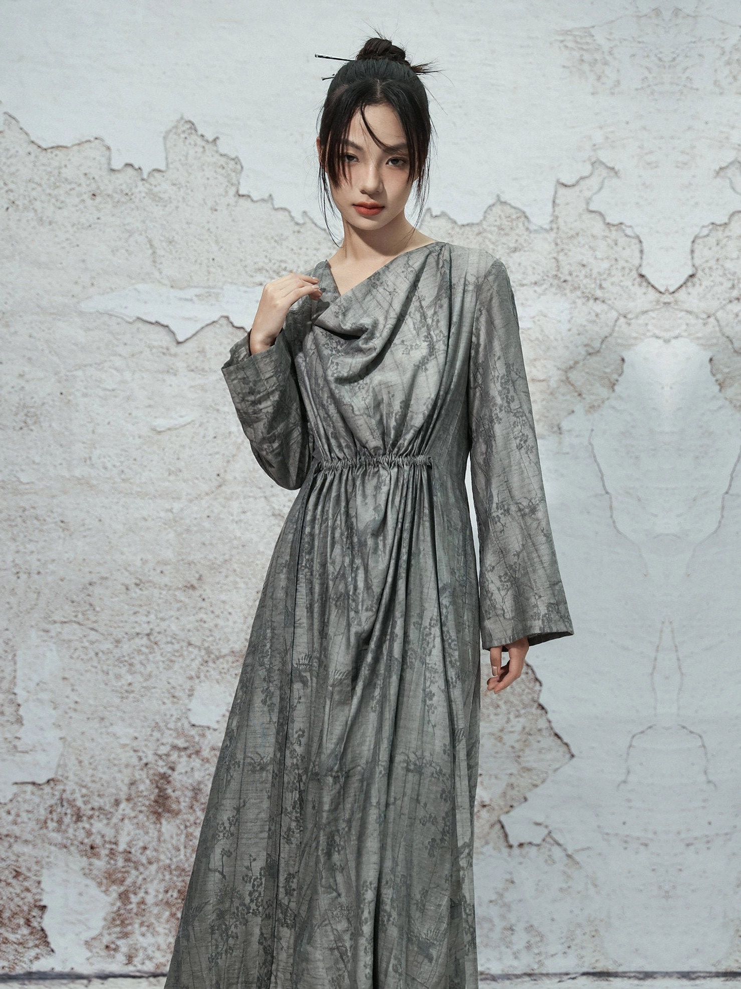Front detail view of dusty grey Chinese-inspired modern Hanfu dress featuring a softly draped cowl neckline, long sleeves and gathered waist