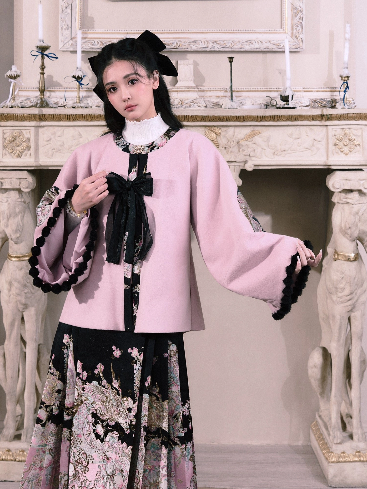 Close view of the dusty pink Ming-style Hanfu jacket with black bow fastening ruffled cuffs and patterned skirt