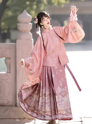 Dusty rose Ming Dynasty Hanfu three piece set with floral stand collar top embroidered vest and pleated mamian skirt shown from the front outdoors