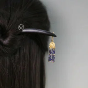 Ebony-style Chinese hair stick with gold filigree pendant and purple-blue beaded tassel worn in a traditional Hanfu updo