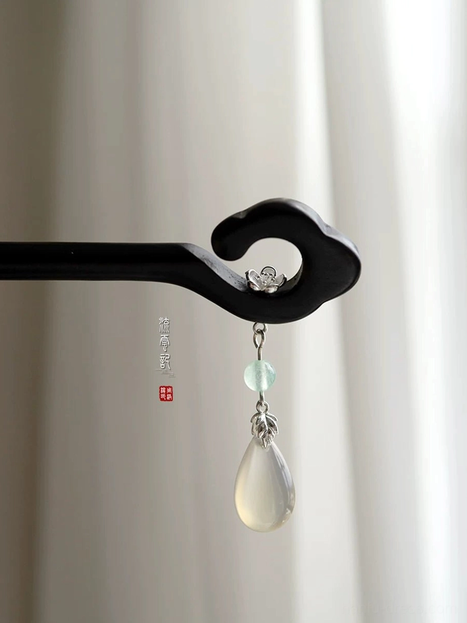Side view of elegant black Chinese hair stick featuring a cloud top, silver-tone floral ornament, and pale green pendant